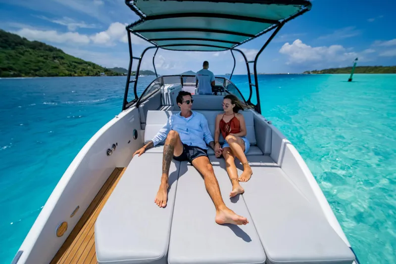 Slide: The Image of Couple relaxing on Rand Supreme 27 boat, 2025 model, in clear turquoise waters. - 12