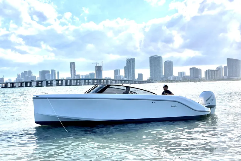 Slide: The Image of 2025 Rand Supreme 27 boat on water with city skyline in background. - 19