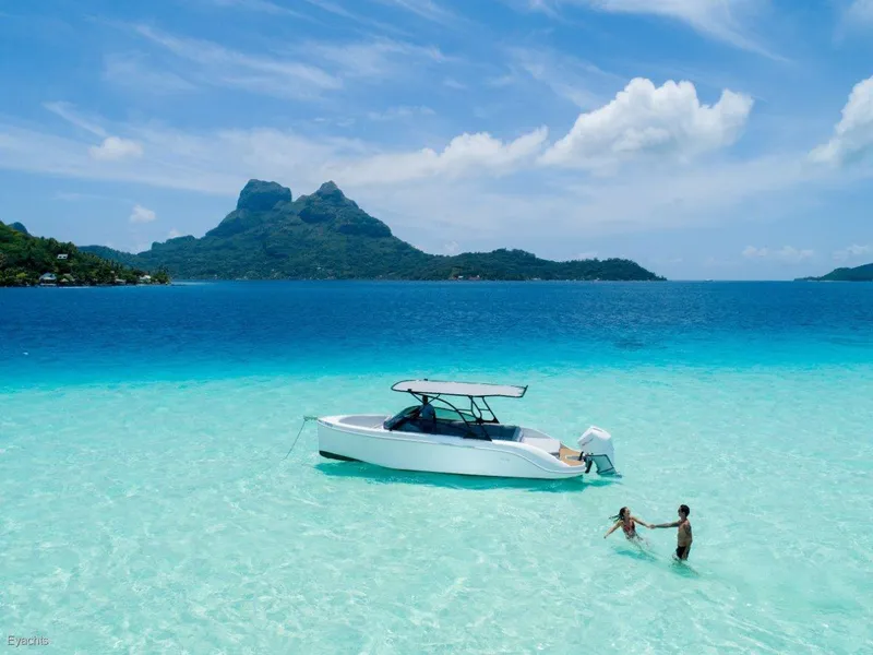 Slide: The Image of 2025 Rand Supreme 27 boat in turquoise waters, tropical island backdrop, people enjoying the sea. - 2