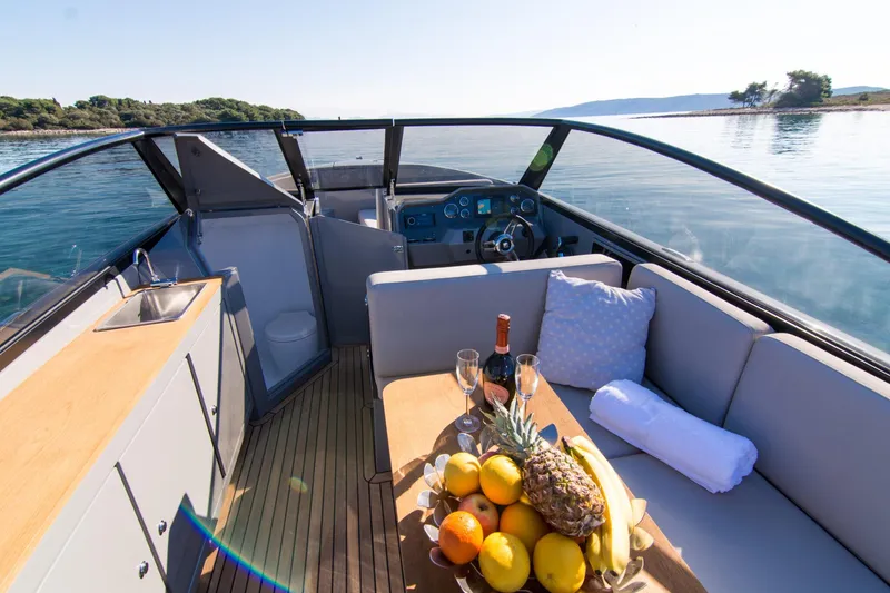 Slide: The Image of Luxurious 2025 Rand Supreme 27 boat interior with fruit platter and scenic water view. - 21