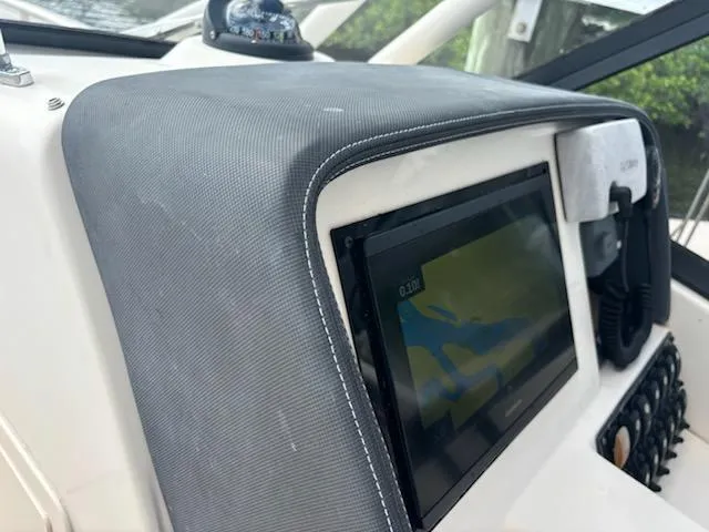 Slide: The Image of Dashboard of 2016 Grady-White Freedom 275 boat with navigation screen and controls. - 16