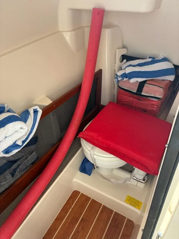 Slide: The Image of 2016 Grady-White Freedom 275 boat interior with toilet, towels, and storage. - 19