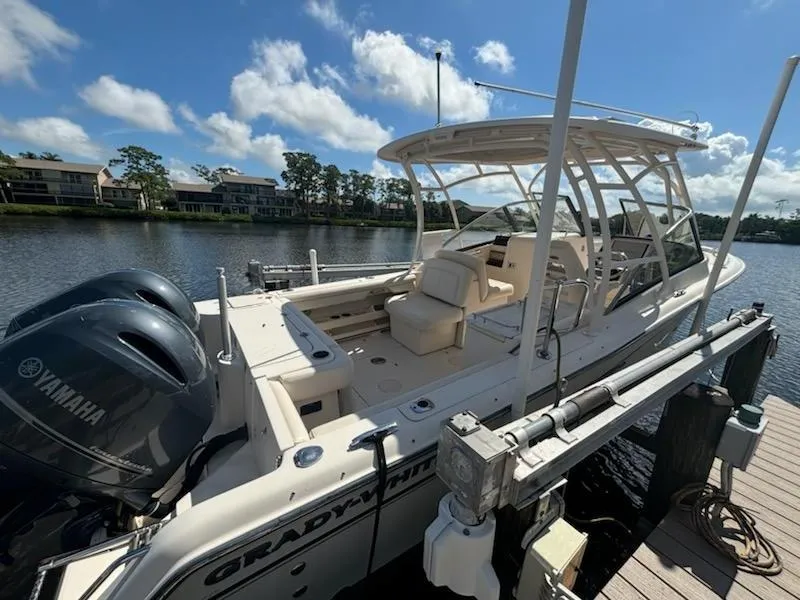 Slide: The Image of 2016 Grady-White Freedom 275 boat docked, featuring dual Yamaha engines, under a clear blue sky. - 2