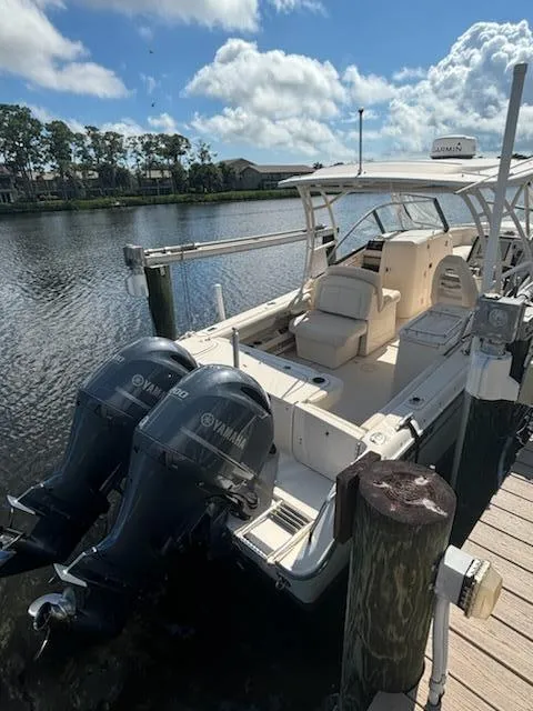 Slide: The Image of 2016 Grady-White Freedom 275 boat docked with twin Yamaha engines, under a partly cloudy sky. - 22