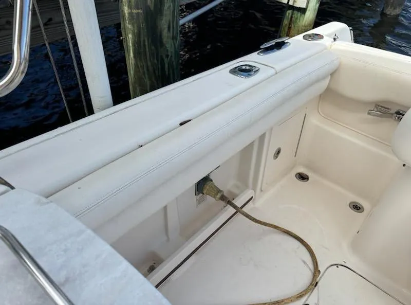 Slide: The Image of 2016 Grady-White Freedom 275 boat interior with white seating and docked at a marina. - 8