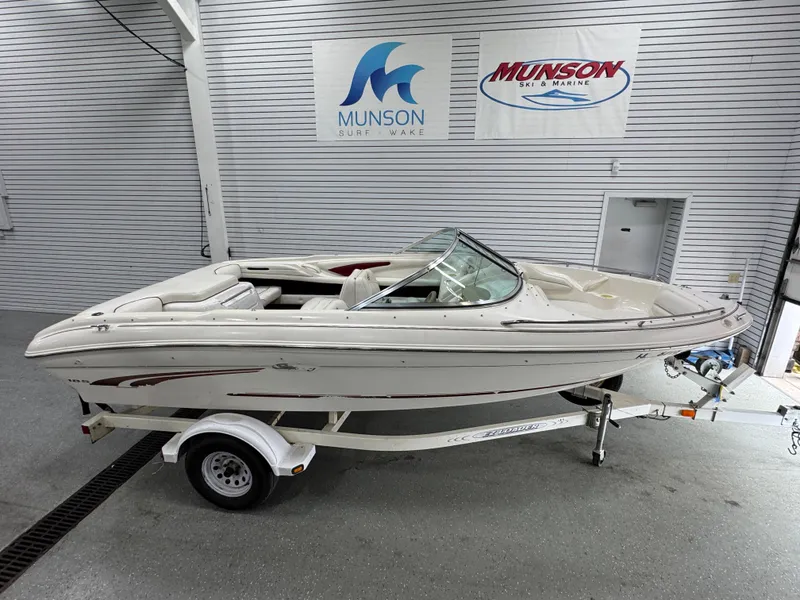 The Image of 1997 Sea Ray 185 BR boat on trailer in showroom with Munson signage. - 1