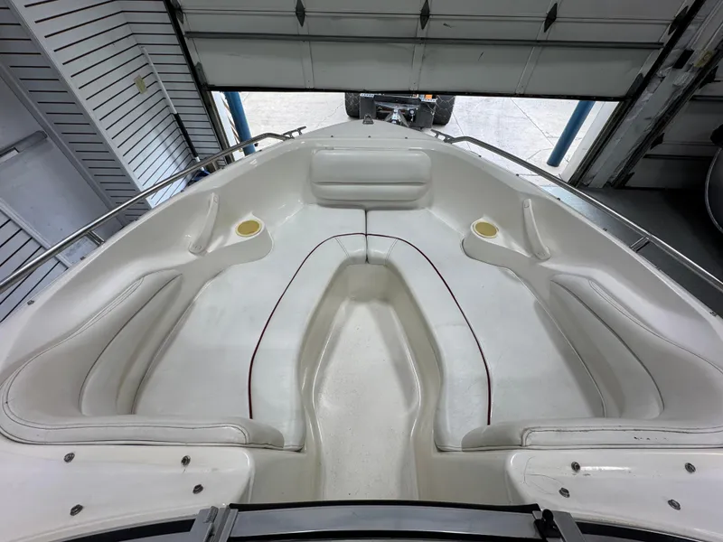 Slide: The Image of 1997 Sea Ray 185 BR boat interior with white seating and cup holders. - 19