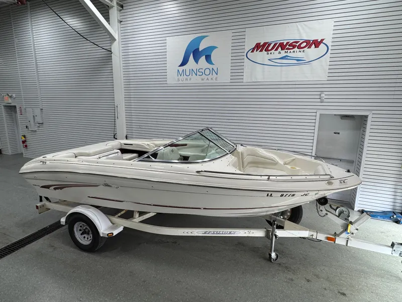 Slide: The Image of 1997 Sea Ray 185 BR boat on trailer in showroom, Munson Marine signage visible. - 3