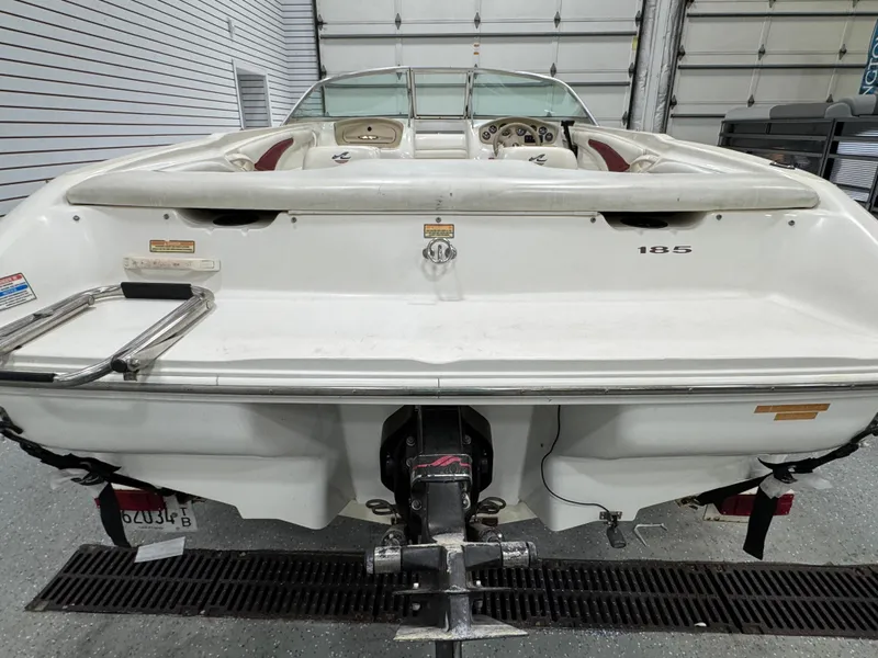 Slide: The Image of 1997 Sea Ray 185 BR boat, rear view in a garage setting. - 6