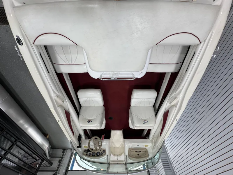 Slide: The Image of 1997 Sea Ray 185 BR boat interior with white and red seating, steering wheel, and dashboard. - 7