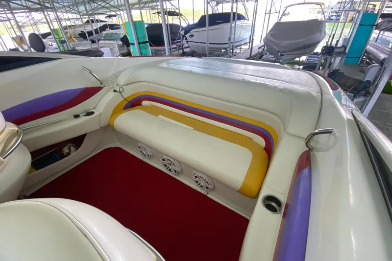 Slide: The Image of Interior of a 1997 Baja 302 Boss boat with colorful seating and red carpet. - 13