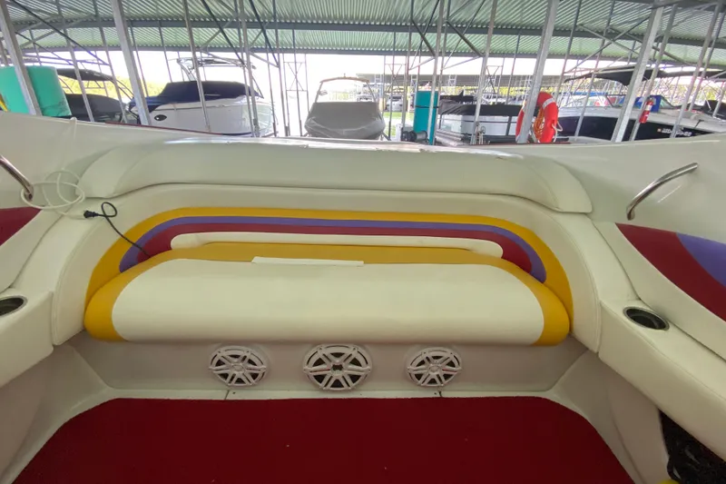 Slide: The Image of Interior of a 1997 Baja 302 Boss boat with colorful seating and speakers. - 14