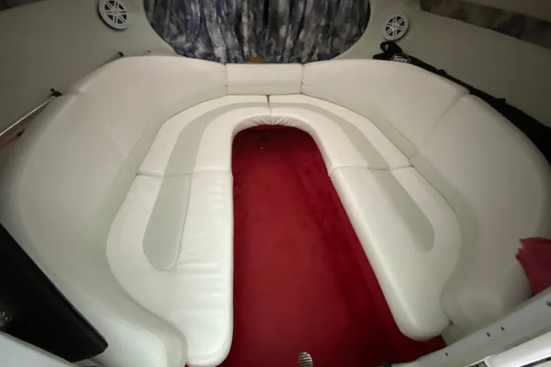 Slide: The Image of Interior of a 1997 Baja 302 Boss boat with white seating and red carpet. - 21