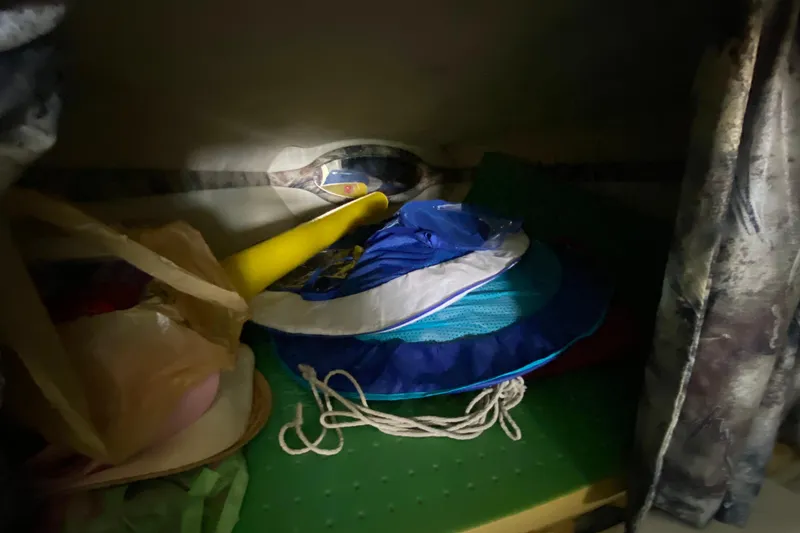 Slide: The Image of Storage area in a 1997 Baja 302 Boss boat with various items. - 22