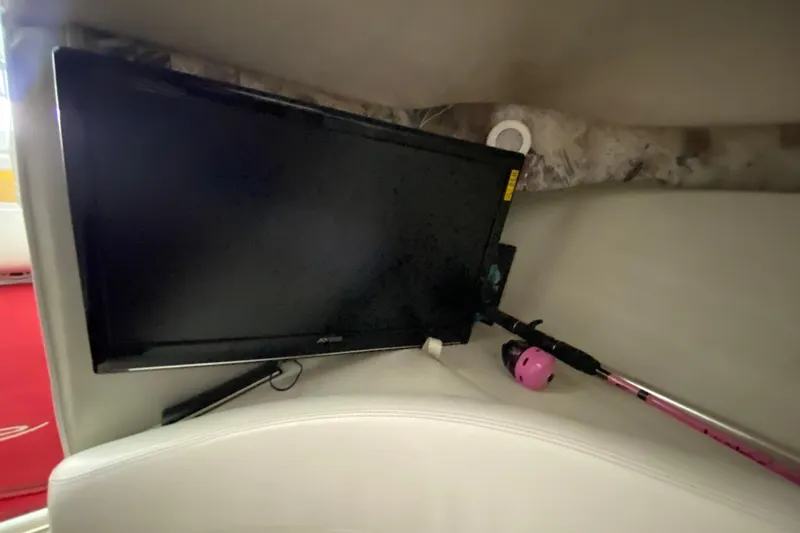 Slide: The Image of Interior of 1997 Baja 302 Boss boat with TV and fishing rod. - 23