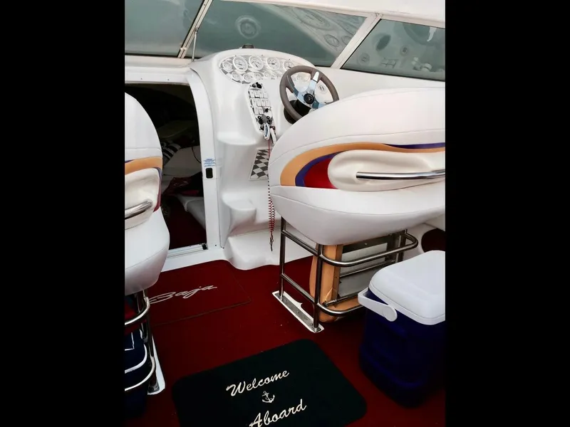 Slide: The Image of Interior of a 1997 Baja 302 BOSS boat with white seats and a "Welcome Aboard" mat. - 4