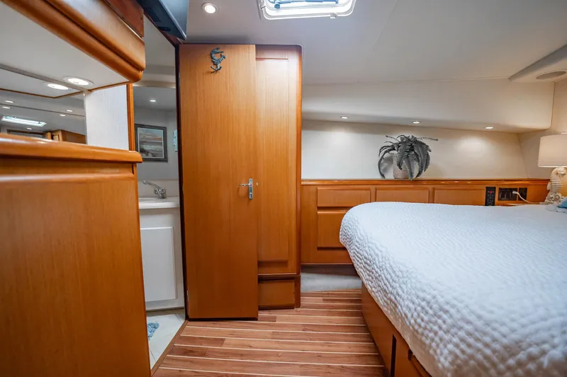 Slide: The Image of Luxurious cabin interior of 2000 Viking 50 Conv Sport Fisher yacht, featuring wood finishes and cozy bedding. - 26
