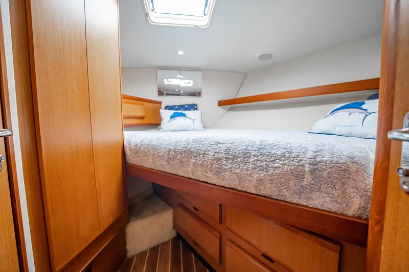 Slide: The Image of Cozy cabin interior of 2000 Viking 50 Conv Sport Fisher with wooden furnishings and bedding. - 29