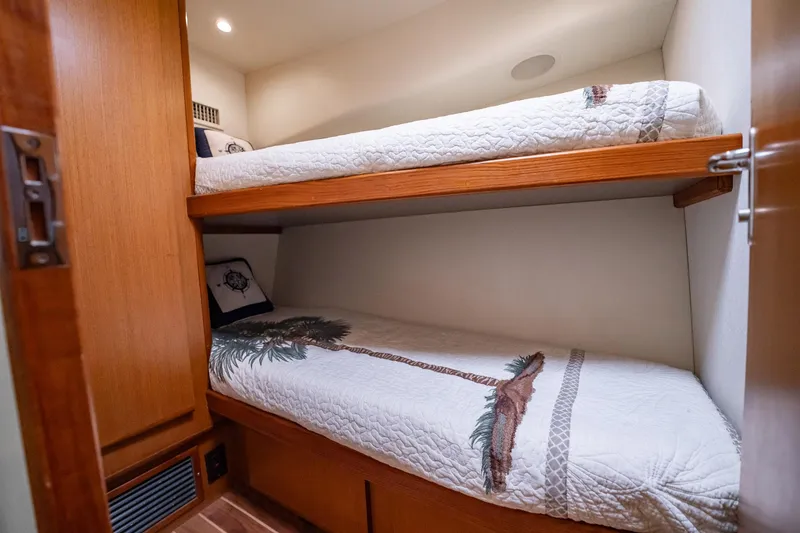 Slide: The Image of Bunk beds in 2000 Viking 50 Conv Sport Fisher, featuring cozy bedding and wooden accents. - 32