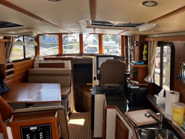 Slide: The Image of Interior of 2022 Ranger Tugs R-31 CB, featuring a cozy cabin with seating and kitchen area. - 11