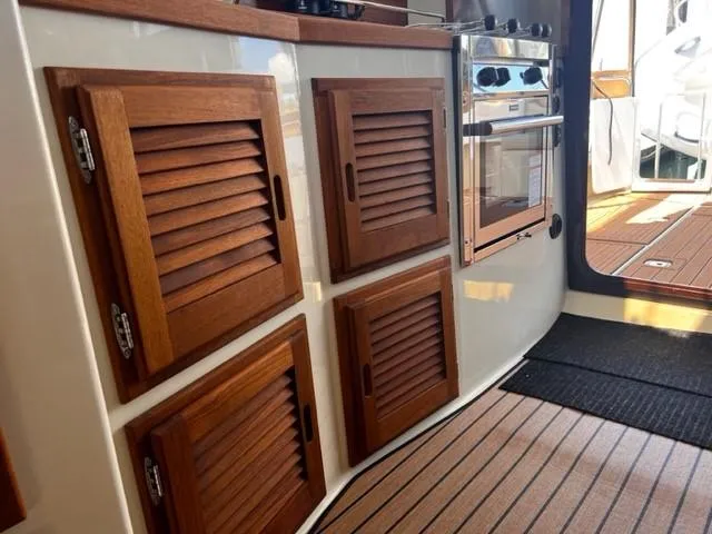 Slide: The Image of 2022 Ranger Tugs R-31 CB interior with wooden cabinets and modern appliances. - 13