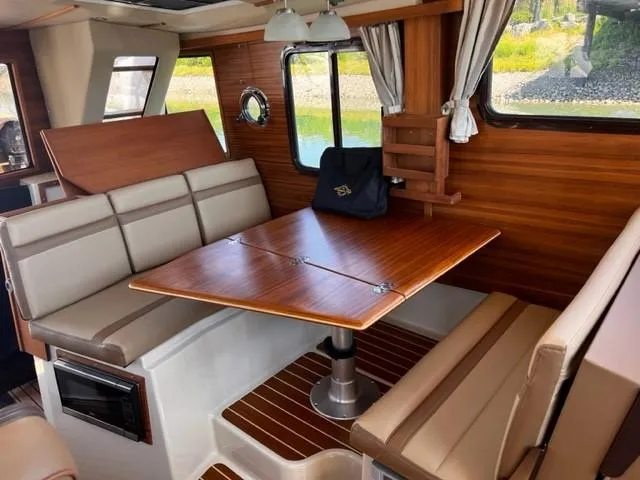 Slide: The Image of Interior of 2022 Ranger Tugs R-31 CB with wood accents and dining area. - 14