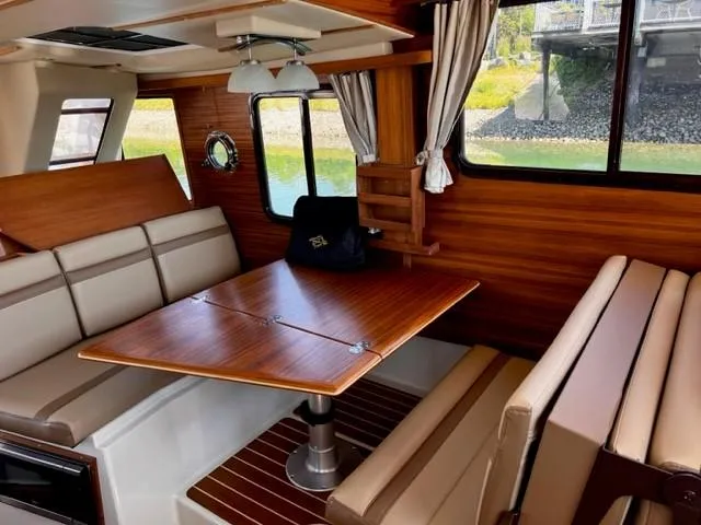 Slide: The Image of Interior of 2022 Ranger Tugs R-31 CB with wood accents and dining area. - 15
