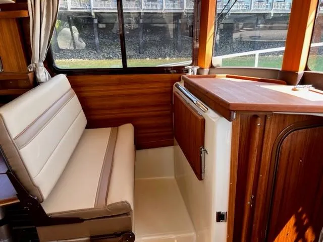 Slide: The Image of 2022 Ranger Tugs R-31 CB interior with wood finish and seating area. - 17
