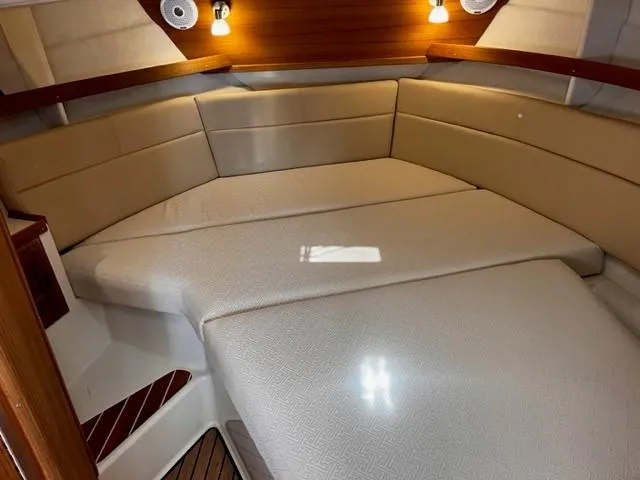 Slide: The Image of 2022 Ranger Tugs R-31 CB cabin interior with beige seating and warm lighting. - 22