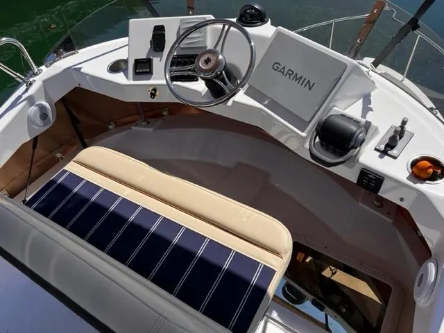 Slide: The Image of 2022 Ranger Tugs R-31 CB helm with Garmin navigation system and striped seating. - 27