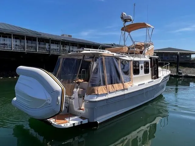 Slide: The Image of 2022 Ranger Tugs R-31 CB boat docked in marina, featuring covered deck and modern design. - 6