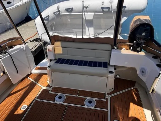 Slide: The Image of 2022 Ranger Tugs R-31 CB boat interior with teak flooring and cushioned seating. - 7