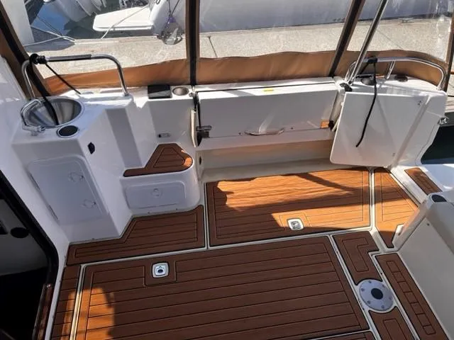 Slide: The Image of 2022 Ranger Tugs R-31 CB boat interior with wood flooring and compact sink area. - 8