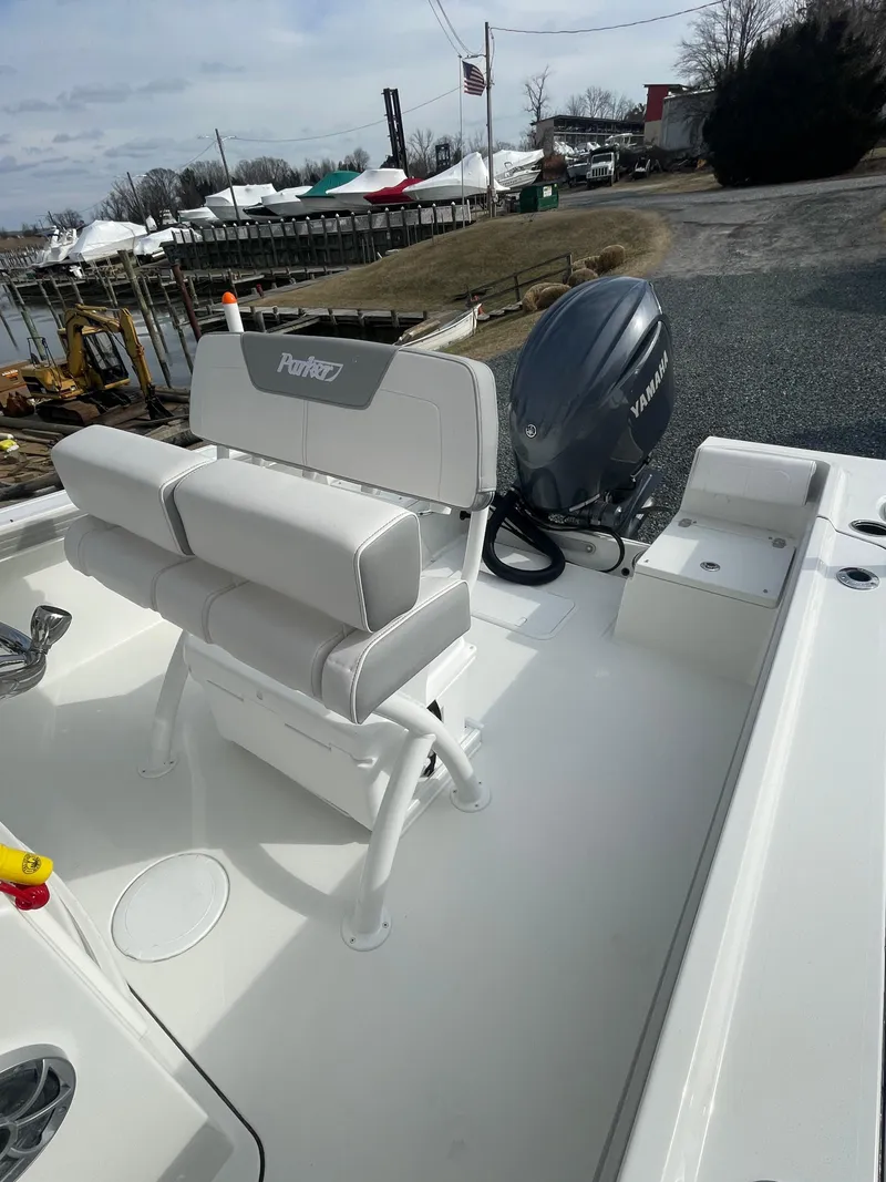 Slide: The Image of 2025 Parker 2100 Special Edition boat with Yamaha outboard motor, docked near a marina. - 8