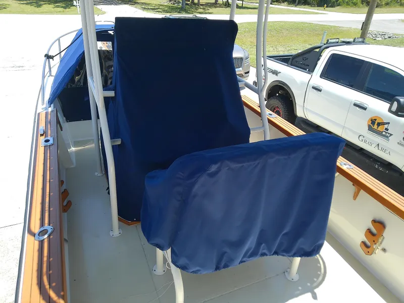Slide: The Image of 1985 Robalo 2520 Center Console boat with blue seat covers and wooden trim. - 12