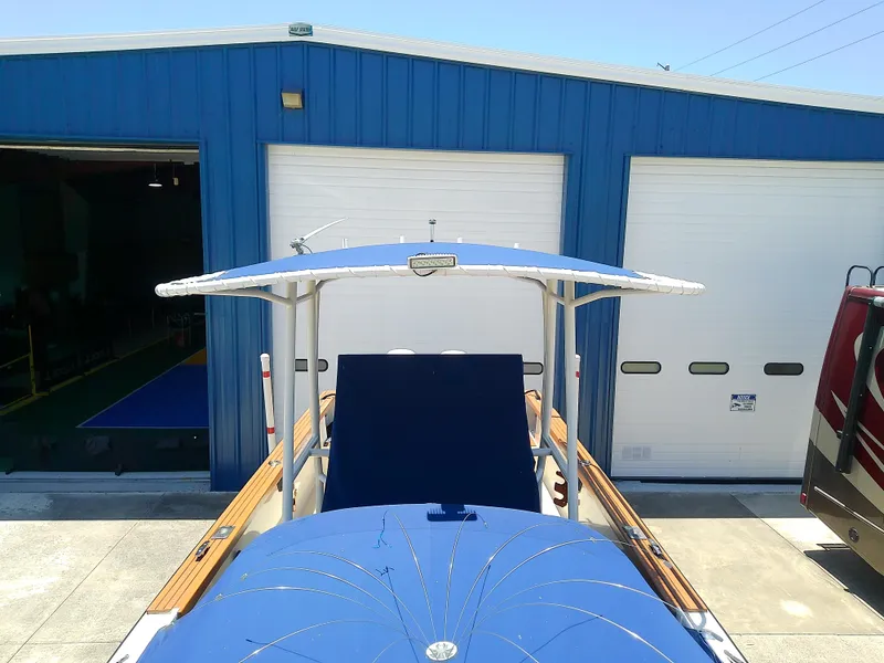 Slide: The Image of 1985 Robalo 2520 Center Console boat parked outside blue garage. - 19