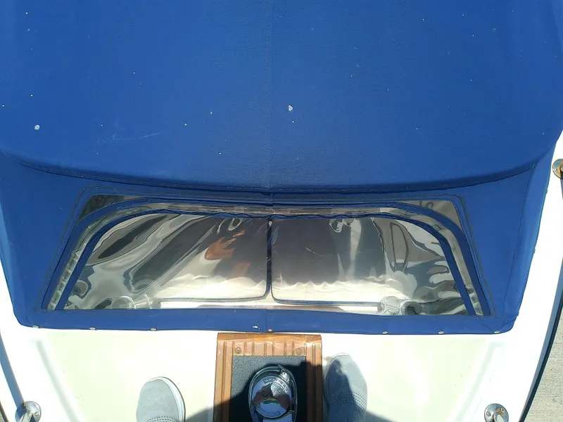 Slide: The Image of 1985 Robalo 2520 Center Console boat with blue cover and clear windshield. - 20