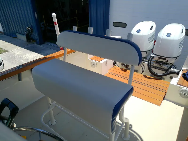 Slide: The Image of 1985 Robalo 2520 Center Console boat with dual outboard engines and cushioned seating. - 23