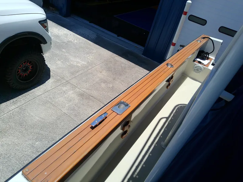Slide: The Image of 1985 Robalo 2520 Center Console boat with wooden deck detail in a garage setting. - 24