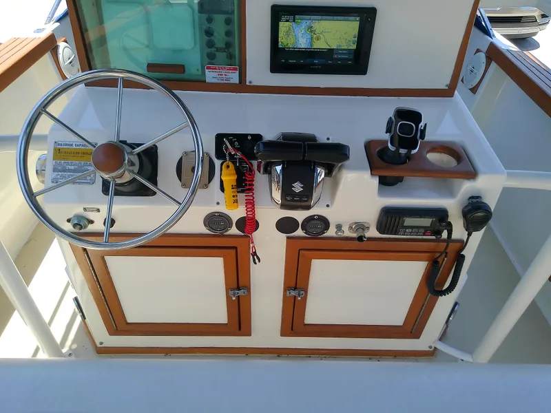 Slide: The Image of 1985 Robalo 2520 Center Console helm with steering wheel, navigation equipment, and controls. - 27