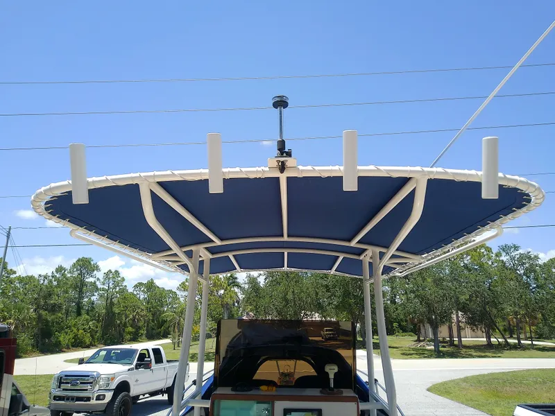 Slide: The Image of 1985 Robalo 2520 Center Console boat with blue T-top and rod holders. - 39