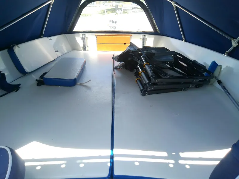 Slide: The Image of 1985 Robalo 2520 Center Console boat interior with blue cushions and folded equipment. - 45