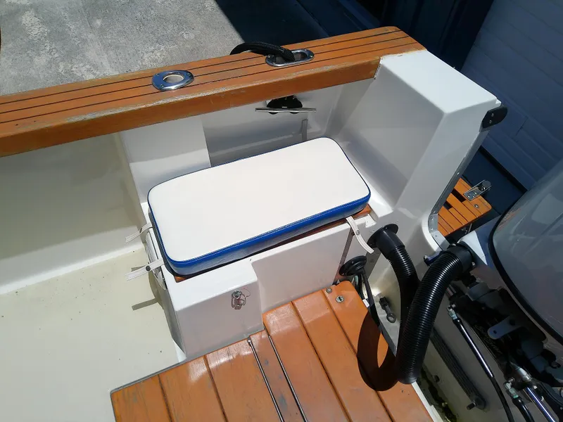 Slide: The Image of 1985 Robalo 2520 Center Console boat interior with cushioned seat and wooden deck. - 48