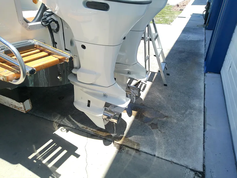 Slide: The Image of 1985 Robalo 2520 Center Console boat with dual outboard motors on a concrete surface. - 6