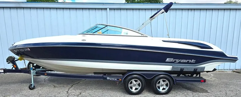Slide: The Image of 2008 Bryant 246 BR boat on trailer, blue and white design, parked outdoors. - 0