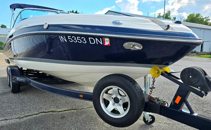 Slide: The Image of 2008 Bryant 246 BR boat on trailer, navy and white, parked outdoors. - 12