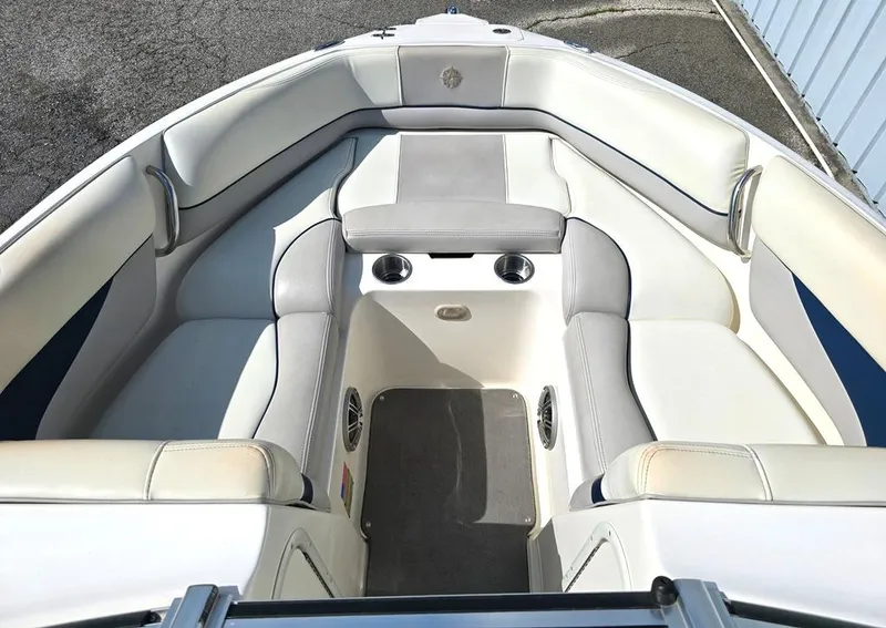 Slide: The Image of 2008 Bryant 246 BR boat interior with white cushioned seating and cup holders. - 4