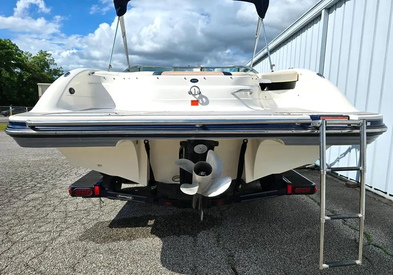 Slide: The Image of 2008 Bryant 246 BR boat rear view with propeller and ladder, parked outdoors. - 7