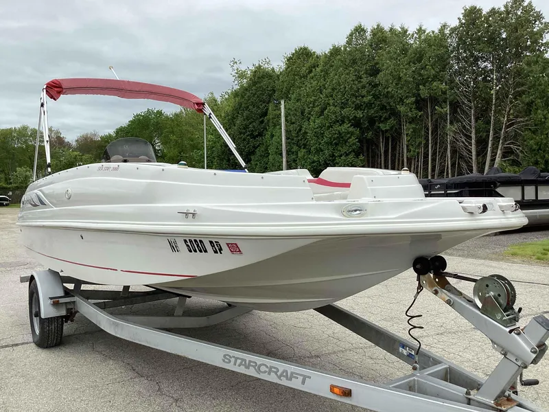 Slide: The Image of 2006 Starcraft SeaStar 2000 boat on trailer with red canopy, parked outdoors. - 3