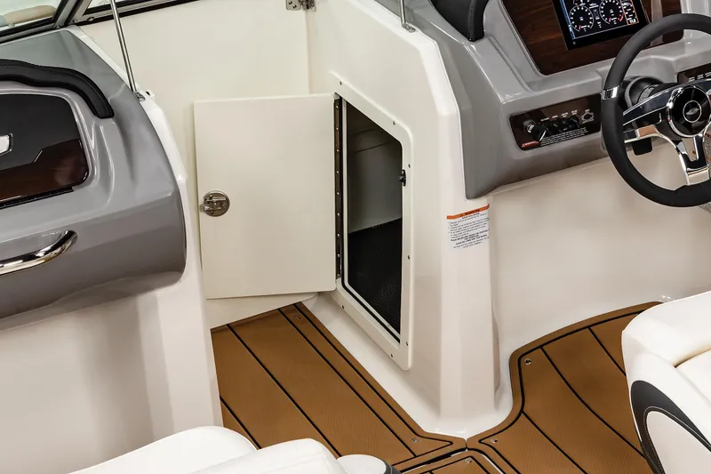 Slide: The Image of 2025 Chaparral 21 SSi boat interior with open storage compartment and modern dashboard. - 16